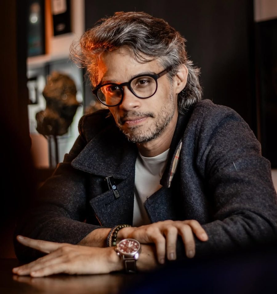 Marcos Strider de óculos, sentado à mesa